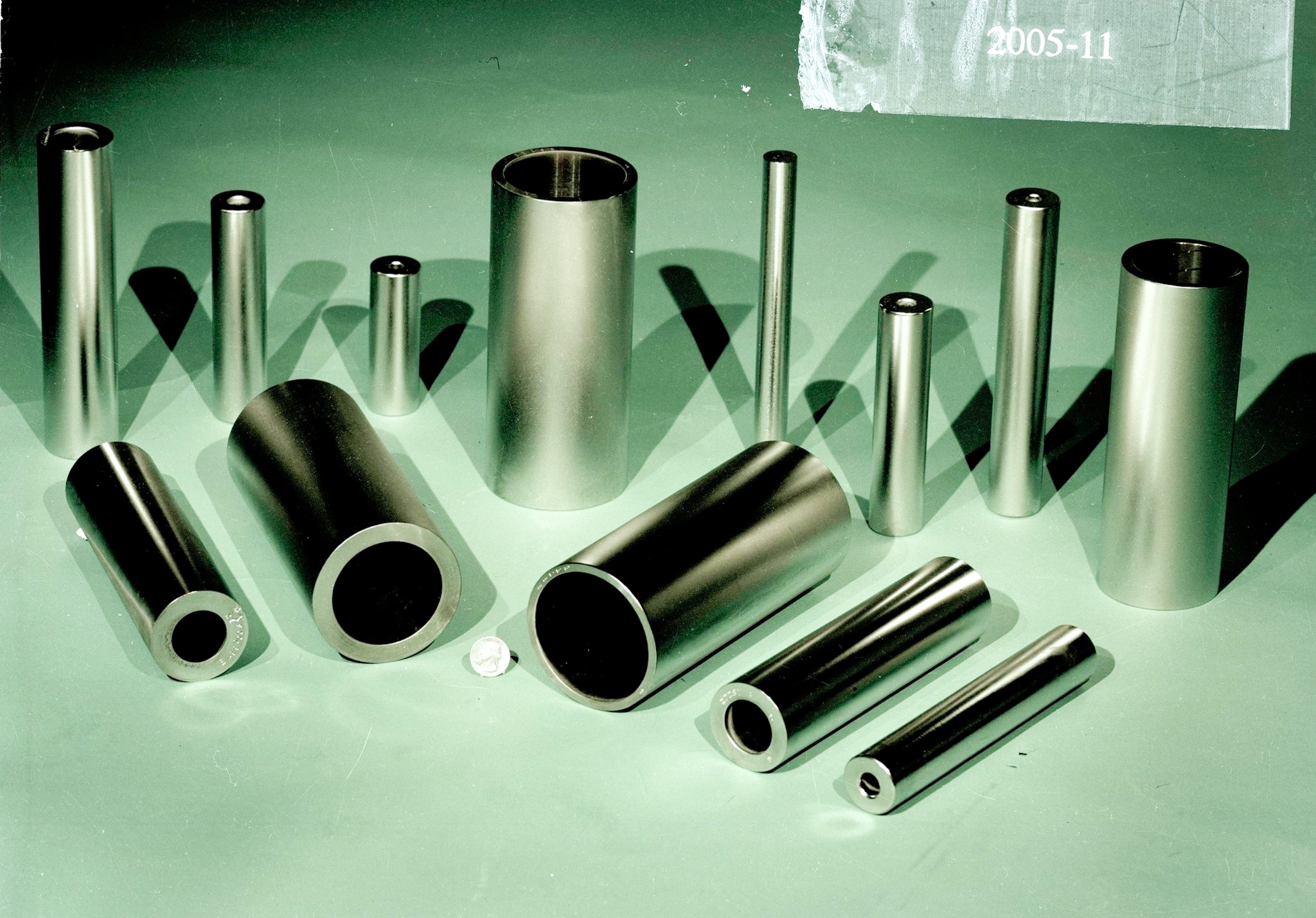 Finished uranium metal rods and tubes arranged on a green surface