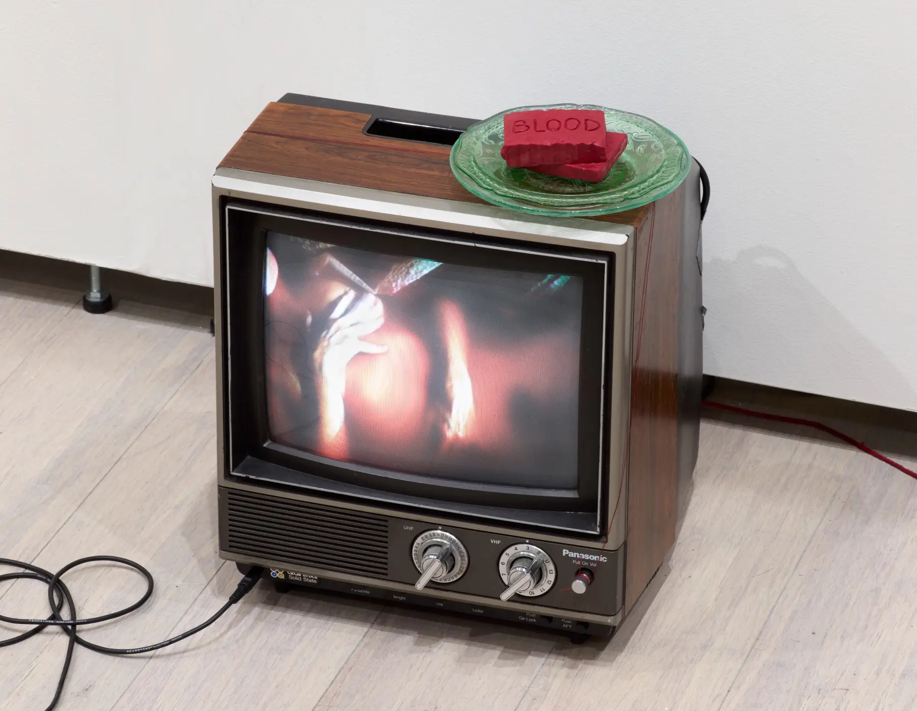 A vintage CRT television playing Blood Bath with two red bars of soap on a green glass plate